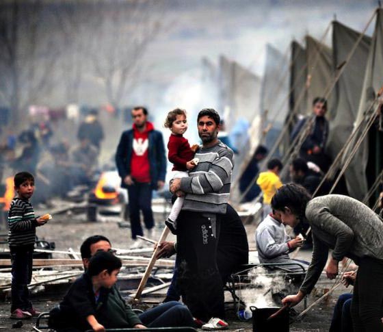 A refugee man holding a child