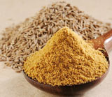 A cup of cumin beside the grains that make it